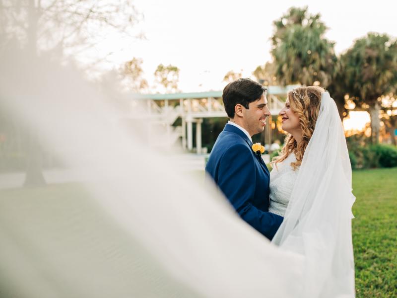 A bride and groom gaze into each other's eyes outdoors at Rosen Plaza, a dream wedding venue in Orlando. 