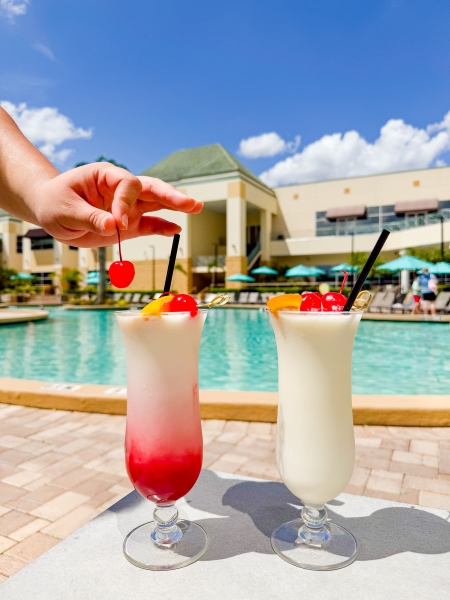 Two drinks sitting on a pool deck at Rosen Plaza, a family-friendly hotel in Orlando.