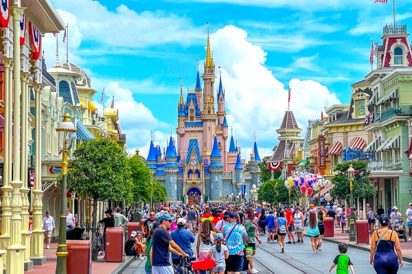 Crowds walking along Main Street USA towards Cinderella Castle at Magic Kingdom.