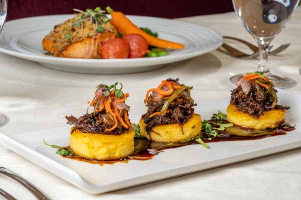 Three small polenta discs on a plate topped with short rib for Magical Dining 2026 at Jack's Place.