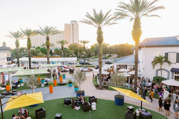 A sun setting in between palm trees at Pointe Orlando, a lively entertainment complex near Rosen Plaza Hotel on International Drive in Orlando.