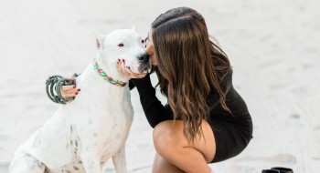 A young woman kisses her dog on the muzzle while out for a walk at Rosen Plaza, a dog friendly hotel in Orlando.