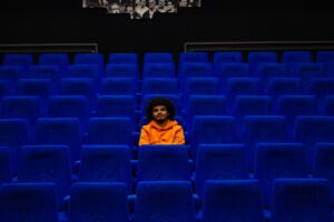 Man watching a movie alone, which is a great way to practice for solo travel.
