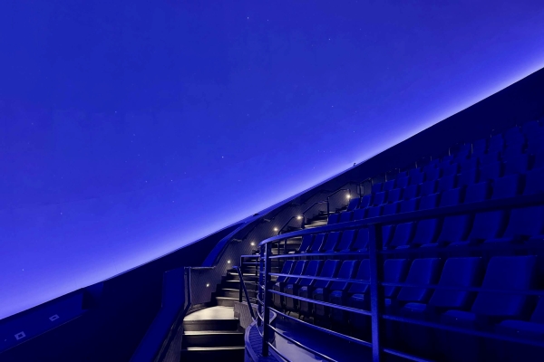 A dark blue screen curves over rising theatre seats at The Dome, located at Orlando Science Center.