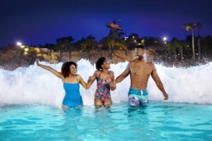 A family holds hands and runs through a wave pool at Typhoon Lagoon, an Orlando water park at Walt Disney World Resort