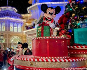 Mickey’s Very Merry Christmas Party - Mickey Mouse poses with gifts and a Christmas tree in Magic Kingdom as Minnie greets guests.